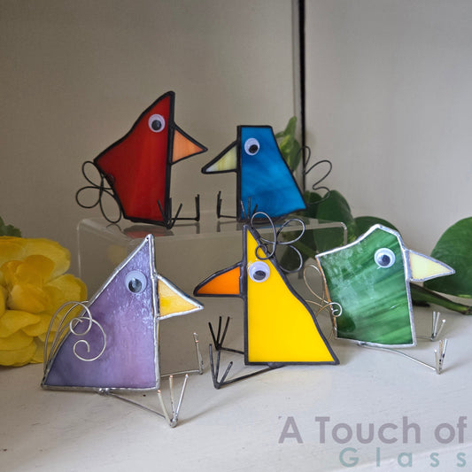 The whimsical scrap glass bird is colourful, charming and imaginative exuding a playful and fanciful aura with its quirky design and delightful character.